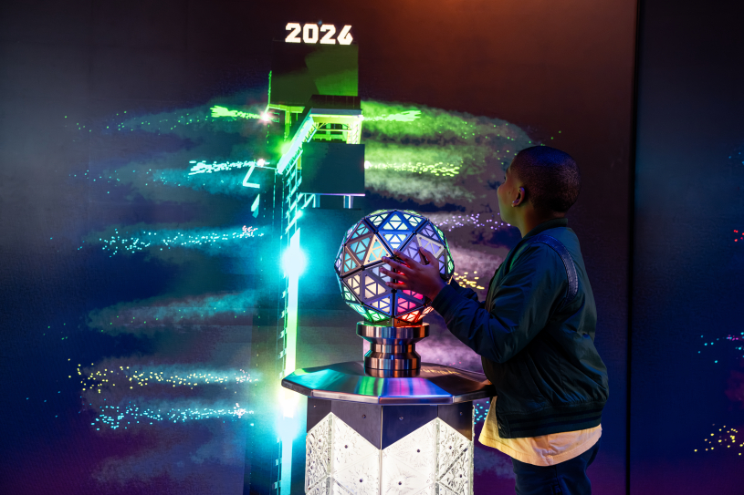 Ein Gast der Ausstellung „Times Travel“ im One Times Square berührt eine Replik des New Year’s Eve Ball.